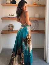 Vestido largo verde con diseño estampado tipo tie-dye y detalles dorados, de corte fluido, un solo hombro y diseño amplio.