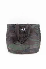 Bolso tote de tela con estampado de camuflaje en tonos verdes y marrones. Tiene asas de hombro y un logo ovalado con letras blancas en el centro.