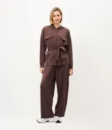 Campera deportiva Get Over de color negro, confeccionada en mezcla de poliéster, modal y elastano. Presenta diseño utilitario con capucha, cierre frontal de botones, bolsillos con solapa en el pecho, mangas largas y lazo ajustable en la cintura.