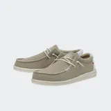 Zapatos Hey Dude modelo Wally Braided, confeccionados en tejido textil color marrón con cordones elásticos beige, costuras visibles en el empeine y suela ligera de goma.