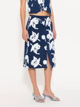 Pollera midi de jean azul con estampado floral blanco y abertura frontal.