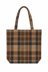 Bolso tipo tote bag con patrón de cuadros tartán en tonos marrón, naranja y negro, con doble asa superior.