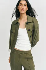 Pantalón recto de tiro bajo en color verde militar, con nervios marcados en la parte delantera, bolsillos frontales y cierre con cremallera, botón interior y ganchos.