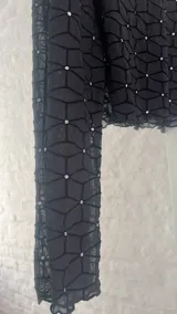 Top negro de microtul con cuello alto y mangas largas.