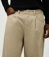 Pantalón chino de sarga color beige, con pinzas frontales, corte recto y largo completo. Cuenta con bolsillos laterales y traseros, cierre frontal con botón y cierre.