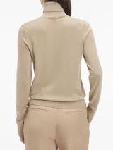 Sweater color beige de tejido de punto, con cuello alto y mangas largas.