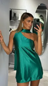 Vestido corto de satén color verde esmeralda, con diseño de un solo hombro y cuello tipo halter integrado. Presenta una caída fluida y corte recto.