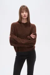 Polera de punto color marrón con destellos brillantes, cuello redondo, mangas largas abullonadas y diseño holgado.
