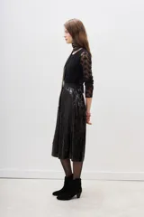 Falda midi de corte evasé, confeccionada en tela negra cubierta completamente de lentejuelas brillantes. Presenta una cintura elástica cómoda y un diseño fluido que aporta movimiento.