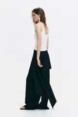 Musculosa blanca de punto acanalado, con escote en U pronunciado tanto en el frente como en la espalda y tirantes finos.