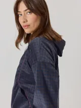 Campera estilo hoodie semi aterciopelada de color azul marino con sutil estampa de cuadros, mangas largas, capucha con cordones ajustables y cierre frontal con botones a presión.