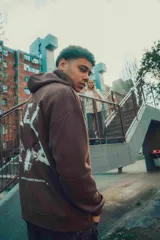 Hoodie marrón de corte oversize con capucha y diseño estampado en la espalda.