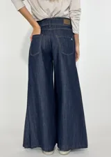 Pantalón de jean azul oscuro, de corte palazzo y tiro alto.