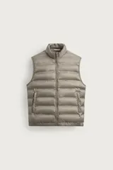 Chaleco acolchado de corte regular fit en color gris, confeccionado en tejido técnico repelente al agua. Presenta cuello subido, bolsillos de vivo en la cadera y cierre frontal con cremallera.