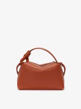 Bandolera de cuero color arena de JW Anderson con el nombre. Bolso esquinero JWA color arena con detalles dorados.