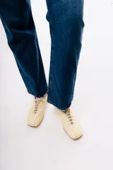 Zapato acordonado de cuero color negro, de diseño minimalista con punta cuadrada y silueta moderna.