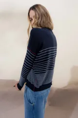 Sweater color crema con rayas horizontales y mangas largas.