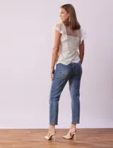 Blusa de dos piezas color blanco, marca Cupio. La pieza superior es de tul bordado con escote en V con botones, manga corta amplia y ruedo con puntilla bordada. Incluye forro interno a tono.