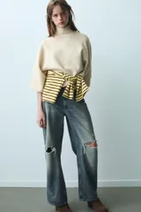 Jersey de punto verde militar, con cuello subido y mangas largas anchas de corte acampanado.