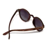 Lentes de sol Indie Hill con montura redonda de madera color marrón y lentes grises polarizadas.