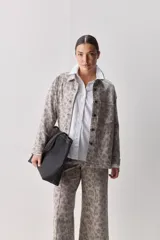 Sobrecamisa de corte relajado con estampado animal print, cuello camisero, cierre frontal con botones, hombros caídos y bolsillo plaqué en el pecho.