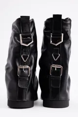 Bota de caña media confeccionada en cuero vacuno color marrón oscuro, con diseño de pliegues en la caña y suela de goma al tono con textura estriada.