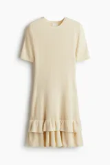 Vestido corto entallado en tejido de punto acanalado de color beige, con escote redondo, mangas cortas y doble vuelo en el bajo.