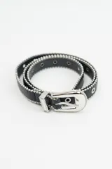 Cinturón negro de cuero sintético con detalle de tachas metálicas plateadas en los bordes y hebilla metálica plateada con diseño grabado.