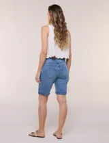 Bermuda de jean color blanco con calce ajustado, confeccionada en denim suave con pretina ancha elastizada sin cierres, bolsillos funcionales y ruedo con vuelta.