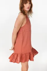 Vestido corto verde militar de lino, con escote halter fruncido en el cuello y detalle de volados en el ruedo.