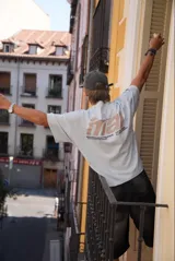 Remera color crema de corte holgado con mangas cortas y estampado en la espalda con el logo de la marca Ittai en color marrón.