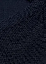 Jersey de punto fino color azul marino, con cuello redondo y manga larga de diseño recto.