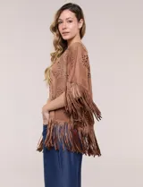 Chaqueta de suede sintético marrón, de corte holgado y frente abierto, con mangas cortas anchas. Presenta diseño de perforaciones láser con motivos circulares y terminación de flecos largos en el ruedo y las mangas.