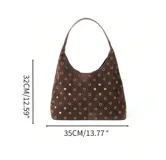 Bolso tipo hobo de gamuza color marrón, con diseño decorado con múltiples ojales metálicos dorados. Incluye una pequeña cartera tipo sobre a juego con correa de muñeca.