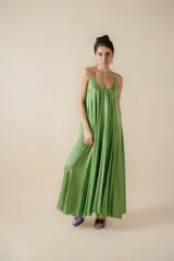 Vestido largo de satén color verde pistacho, con diseño muy amplio y fluido, escote en V pronunciado y tirantes finos.