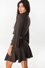 Minifalda color marrón oscuro, confeccionada en lino italiano, con diseño de cintura baja con caderín y bajo acampanado. Cierre invisible en el lateral.