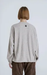 Sweater de tejido jaspeado color beige claro, con cuello redondo, mangas ranglán y elástico ajustable en el bajo.