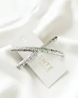 Broche de pelo plateado con forma de cruz y textura martillada.