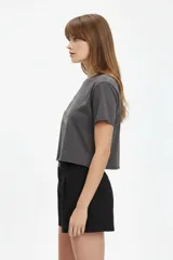 Remera cropped de algodón gris oscuro, con cuello redondo, manga corta y estampa frontal de conejo con estrellas.