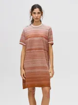 Vestido corto de punto con efecto degradado que transiciona de celeste a bordo, cuello redondo y mangas cortas con puños a rayas en contraste, de corte suelto.