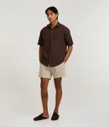 Bermuda playera masculina de corte básico, confeccionada en microfibra texturizada. Presenta cintura elástica con cordón ajustable y bolsillos laterales.