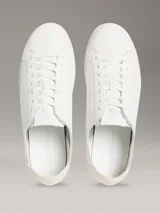 Zapatillas de perfil bajo Calvin Klein en piel color blanco, con suela cupsole de caucho y detalle de monograma grabado en el lateral.