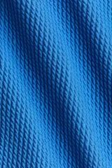 Malla enteriza azul con textura acanalada, escote en V y tirantes anchos con detalle de nudo en los hombros.