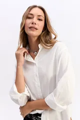 Camisa de corte clásico y líneas limpias, confeccionada en algodón, con cuello camisero, cierre frontal de botones y mangas largas con puños.