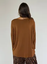 Blusa color beige con escote en V y mangas largas abullonadas.