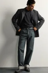 Jeans straight fit de corte recto y tiro medio, confeccionados en denim de algodón oscuro sin lavados, con diseño de cinco bolsillos y bajo vuelto.