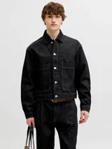 Chaqueta de denim negro con costuras en contraste color blanco, bolsillos frontales con solapa y cierre de botones metálicos.