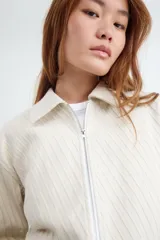 Campera rústica de color beige con diseño a rayas verticales, cuello camisero y cierre frontal de cremallera metálica.