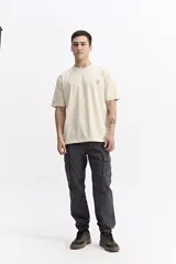 Pantalón cargo de corte relajado color gris oscuro, con cintura elástica y cordón de ajuste, bolsillos laterales con solapa y puños elásticos en los tobillos.