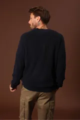 Sweater de punto en color azul marino, con cuello redondo y mangas largas con puños acanalados.
